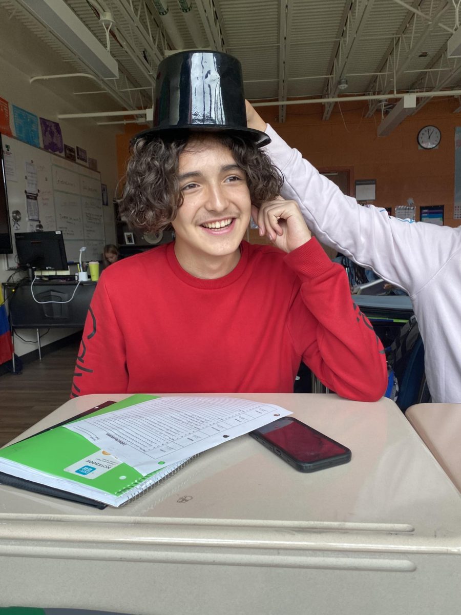 Sophomore Mark Chavez, smiles as a top hat is placed upon his head, to make his look more “Oppenheimer.” Although the atmosphere had a light feel, Chavez and friends discussed a major detail glossed over in the movie; the half-million victims of atomic bomb testing in New Mexico, many of whom were Natives and Hispanics.