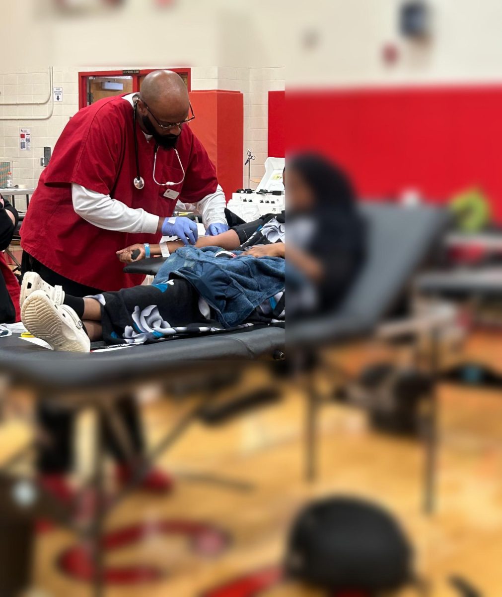 Rishard Nolan collects blood from a student donor.