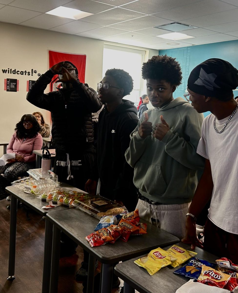 Vincent Tum, Joel Cheruiyot, Paul Turay, Hezekiah Godfrey, play a game of charades. Their team "yahoo boys" compete against other teams during Trivia Night on Oct. 29.