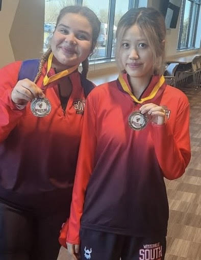 Athlete of the week Sophomore Youxi Zheng with teammate Freshman Arionna Steele at the Queen of the hive invitational on Dec.8. With both of them placing second in their weight class.