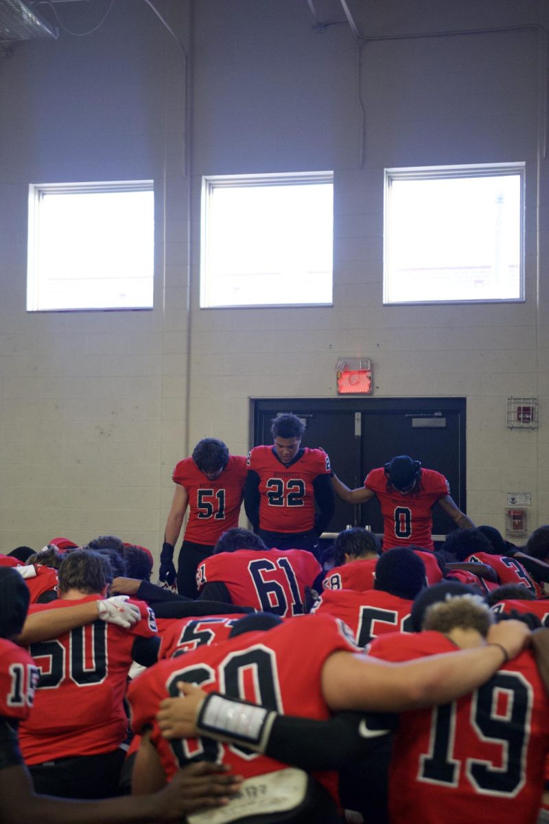 The team kneeling in prayer led by senior London Vickroy, before heading off to face Westerville North.
