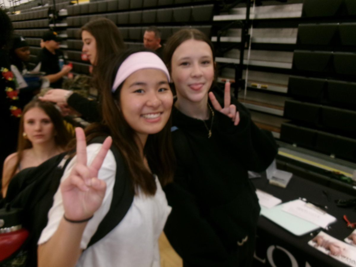 Seniors Yui Seki and Ella Pestorius enjoyed the post-secondary fair and made sure to stop by Salon Institute's booth to get some hair tinsel for free
